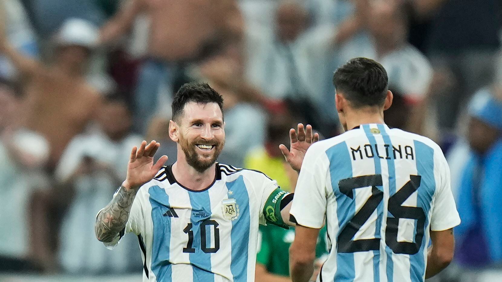 Argentina's Lionel Messi celebrates with Nahuel Molina after their team won the World Cup...