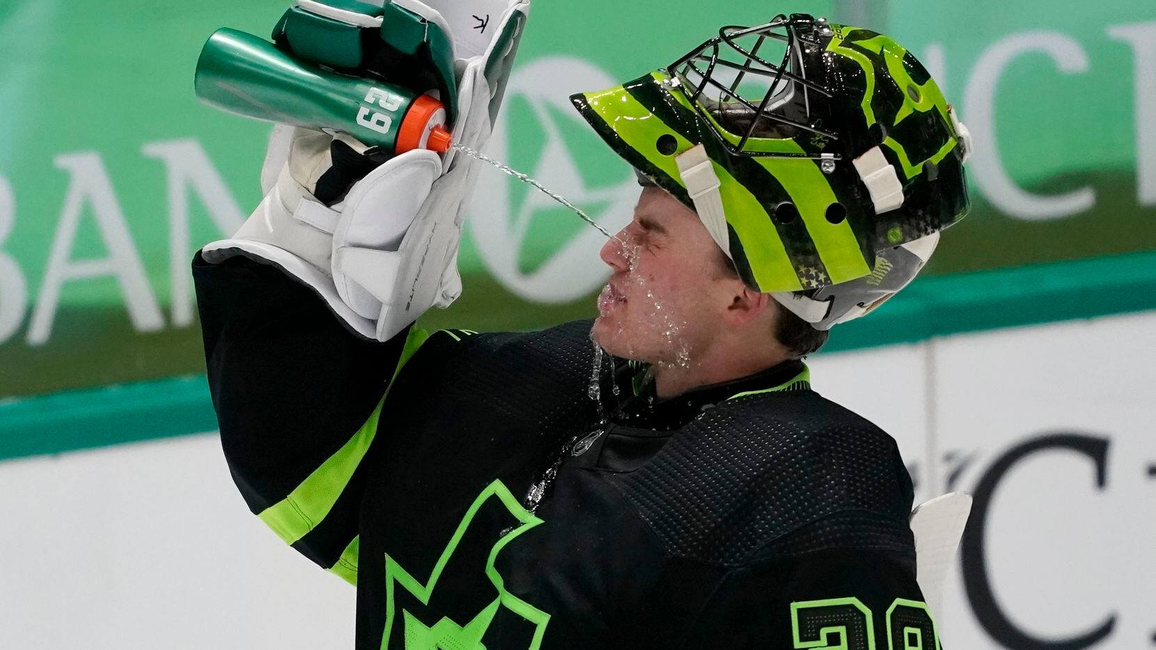 Dallas Stars' Jake Oettinger splashes his face with a drink during a timeout in the second...