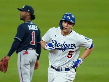 Los Angeles Dodgers shortstop Corey Seager rounds the bases past Atlanta Braves second baseman Ozzie Albies after hitting a 3-run home run during the seventh inning in Game 2 of a National League Championship Series at Globe Life Field on Tuesday, Oct. 13, 2020.