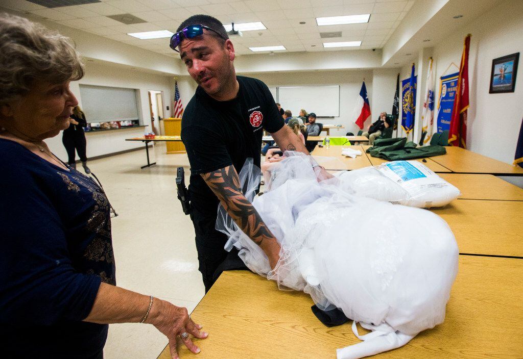 Joyce Brown,  office manager of the Lumberton Central Fire Station, talks to firefighter Kyle Parry, who retrieved the wedding dress of his fiancee, Stephanie Hoekstra, from his home, which was flooded by Harvey. (Ashley Landis/Staff Photographer) 