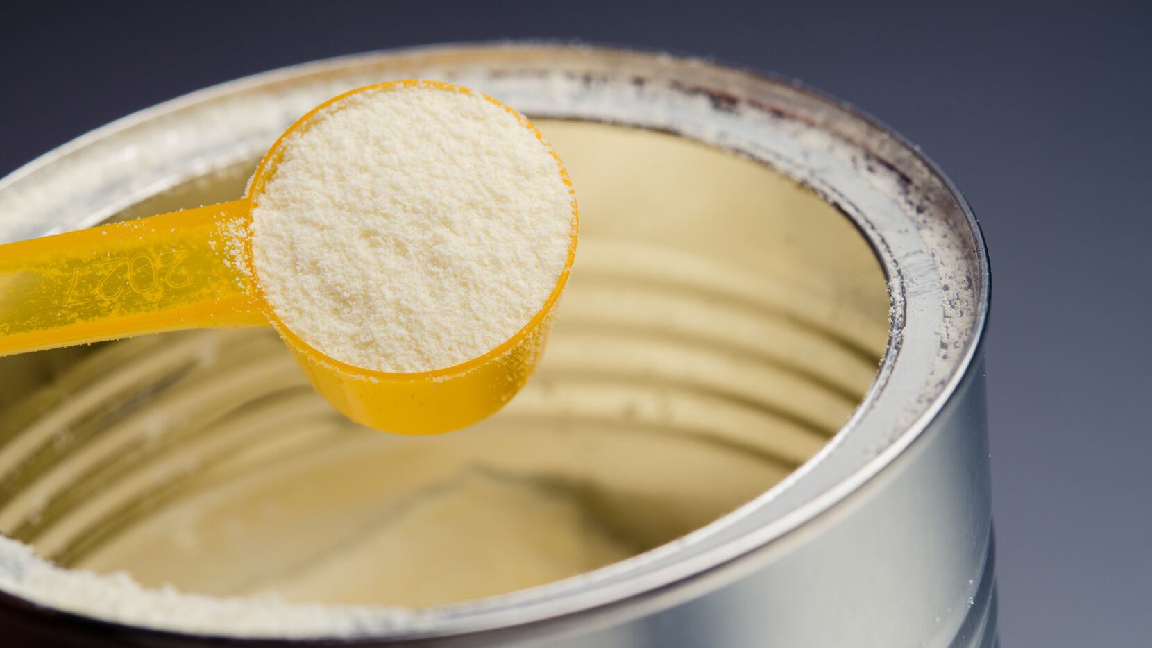 A close-up of baby formula powder in a can.