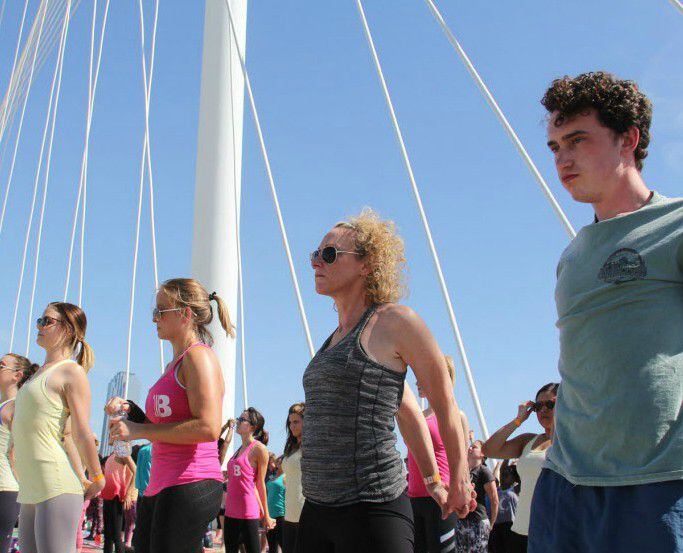 Visitors to the All Out Trinity fitness festival do yoga on the Margaret Hunt Hill Bridge.