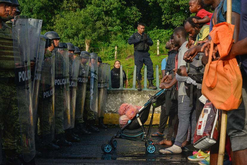 Unos migrantes se enfrentan a miembros de la Guardia Nacional cerca del municipio Tuzantán,...