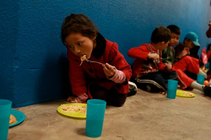 Niños de familias migrantes se refugian en un gimnasio en Ciudad Juárez, mientras esperan...