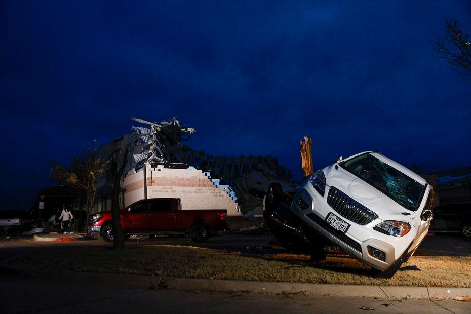 A car rests on a tree stump Tuesday after a tornado in Jacksboro the previous day.