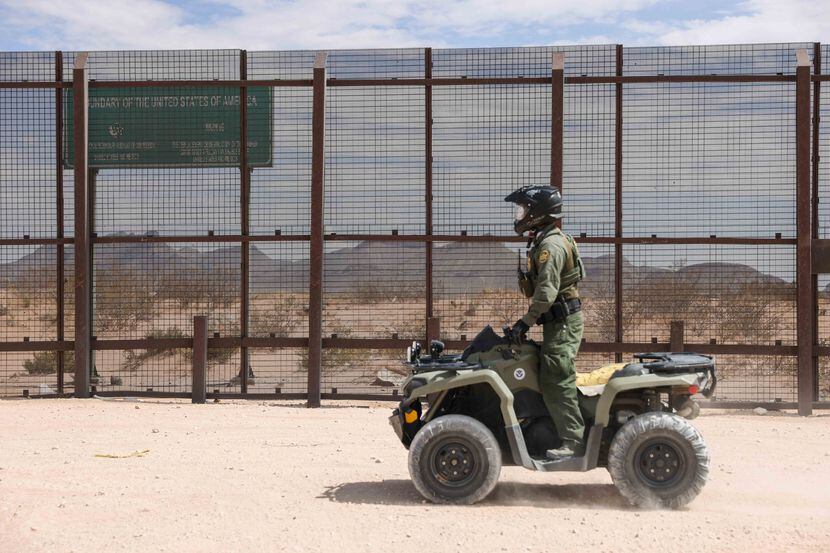 A Border Patrol agent watched a section of the wall at the border with Mexico in Sunland...