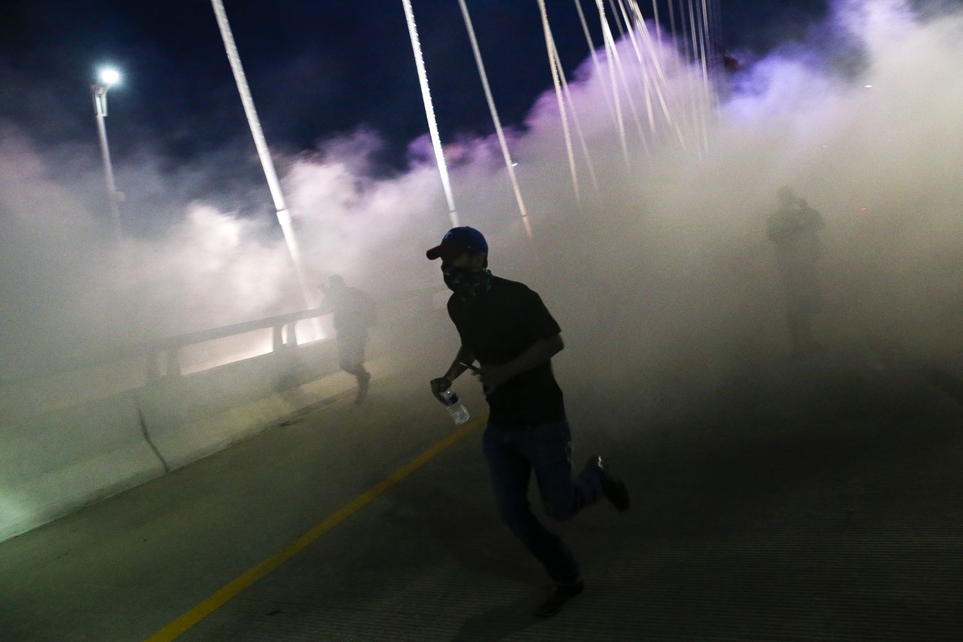 Police deploy smoke bombs and tear gas as they surround protesters who marched onto the...