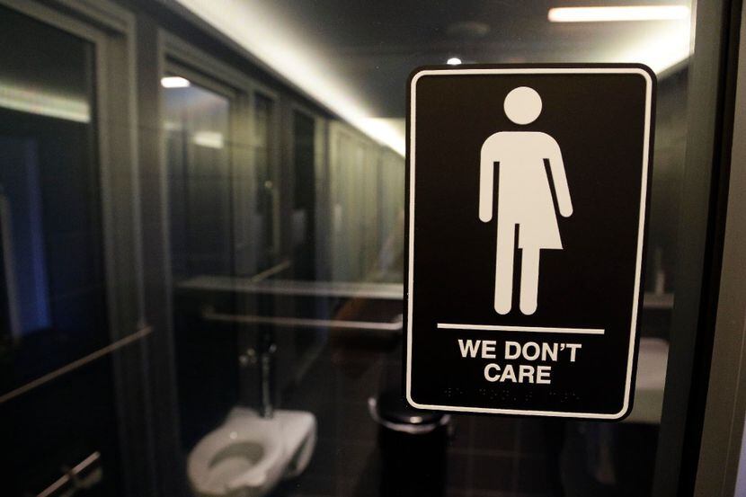 A sign on a restroom at 21c Museum Hotel in Durham, N.C., illuminates the hotel's policy....