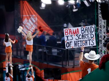 A Texas Longhorns fan flashes a sign behind ESPN’s College GameDay outside Darrell K....