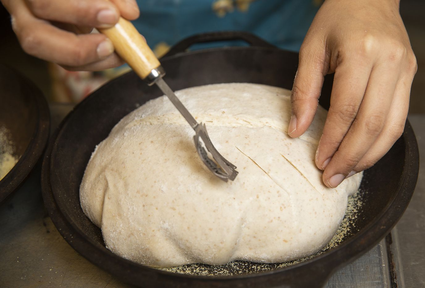 Co-owner Maricsa Trejo knives the sourdough before baking at La Casita Bakeshop on Feb. 12,...