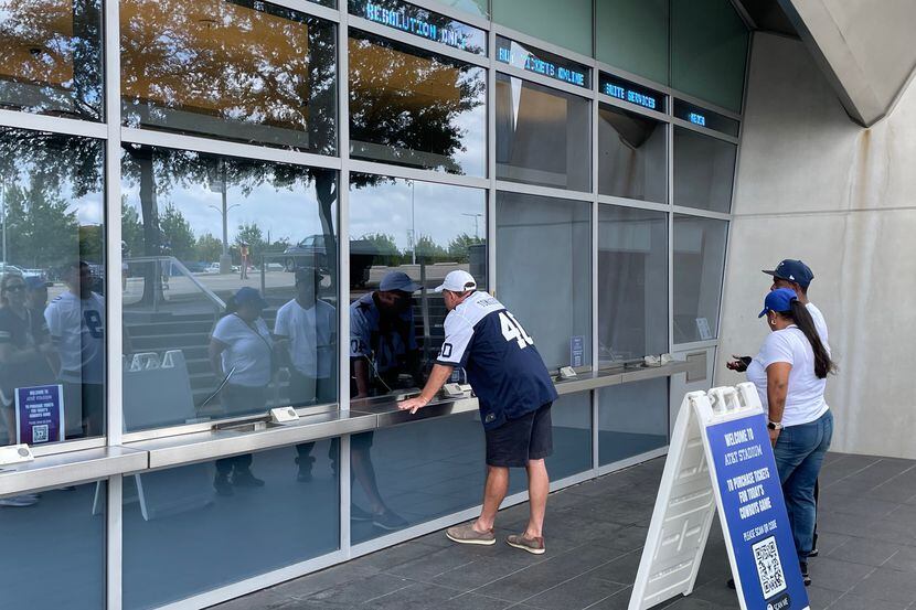 Aficionados  de los Cowboys de Dallas buscan sus boletos en las taquillas del AT&T Stadium.