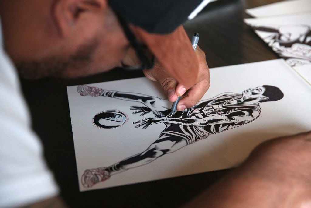 Arturo Torres, a local Dallas artist, touches up a sketch at Common Desk in the Oak Cliff...