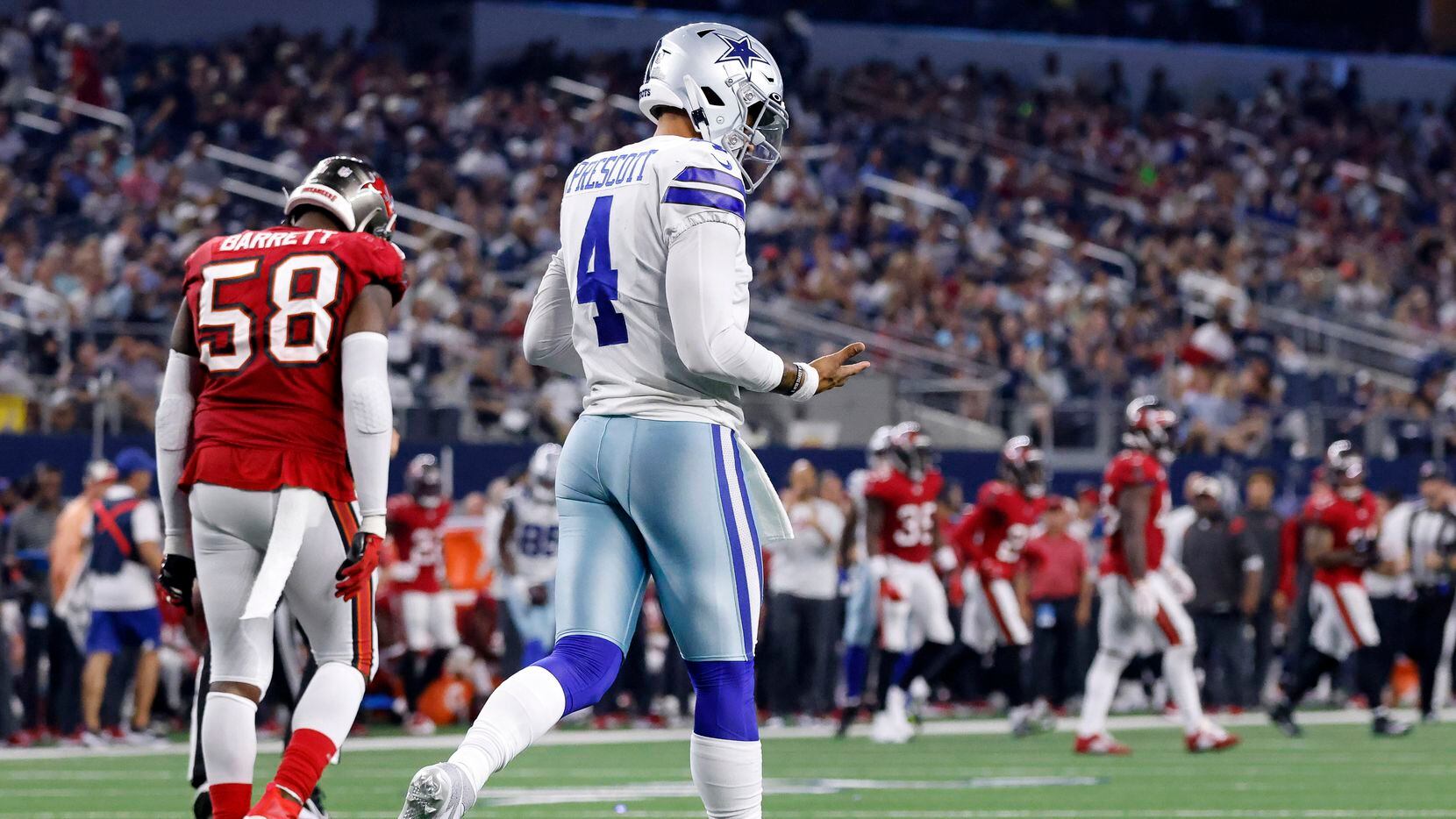Dallas Cowboys quarterback Dak Prescott (4) looks at his throwing hand after hitting it on...