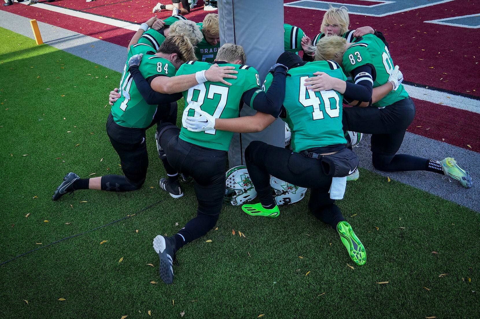 Southlake Carroll player kneed in prayer aroung the goal posts before the Class 6A Division...