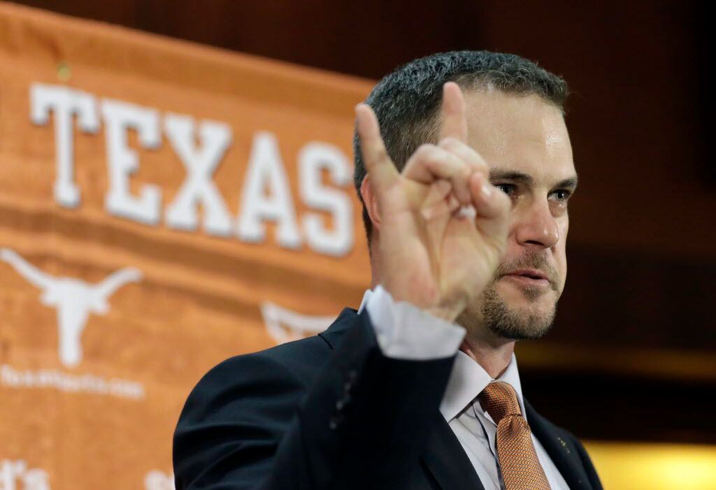Tom Herman holds up the Hook 'em Horns sign during a news conference where he was introduced...