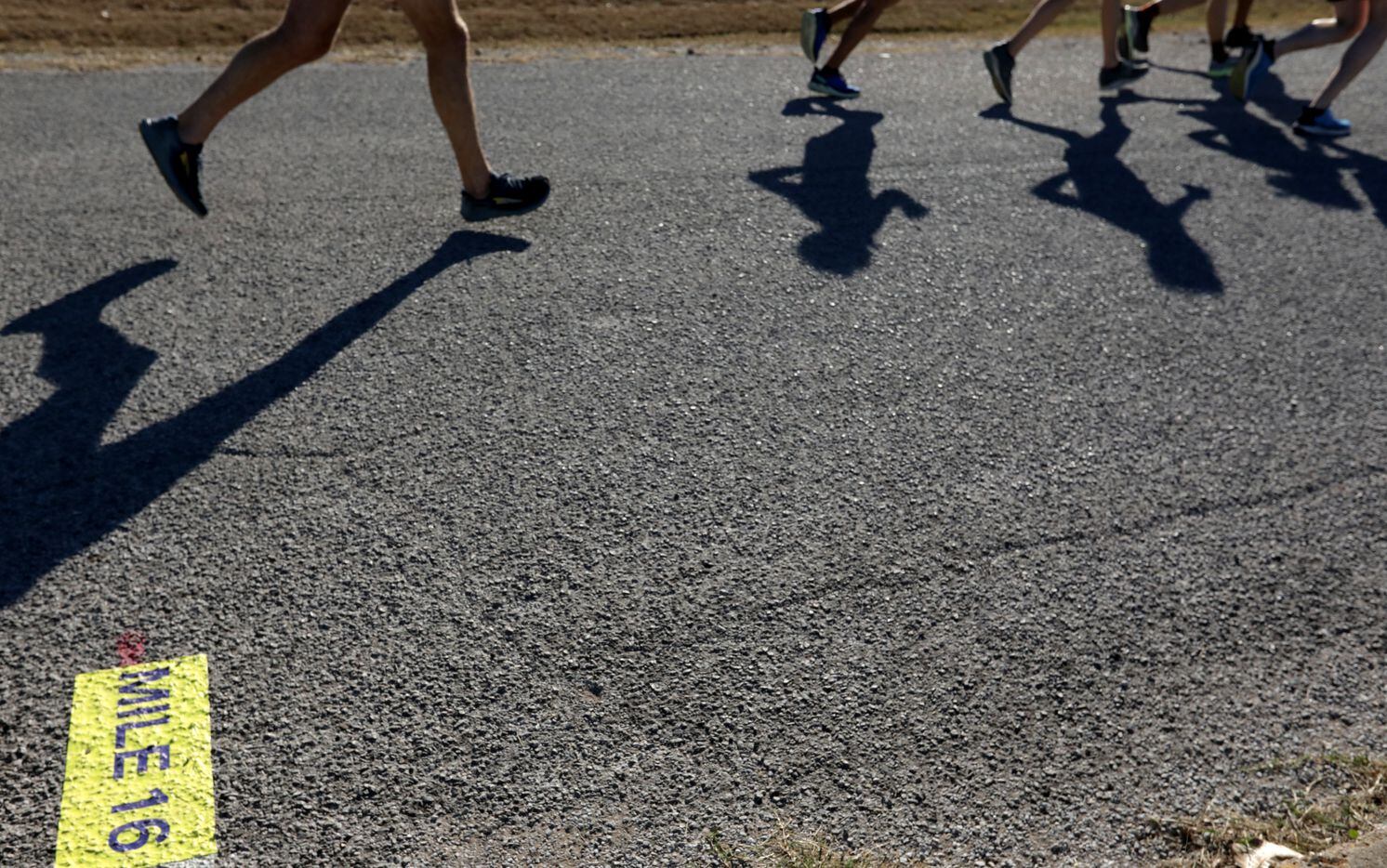 Runners pass the 16 mile marker during the BMW Dallas Marathon at White Rock Lake in Dallas,...