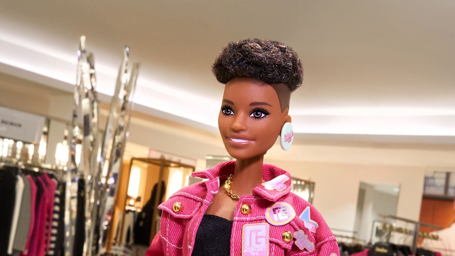 Barbie mannequin wearing an oversize denim jacket with embroidered badges that's part of the Balmain x Barbie pop-up in the Neiman Marcus NorthPark store. Price is $5,350.
