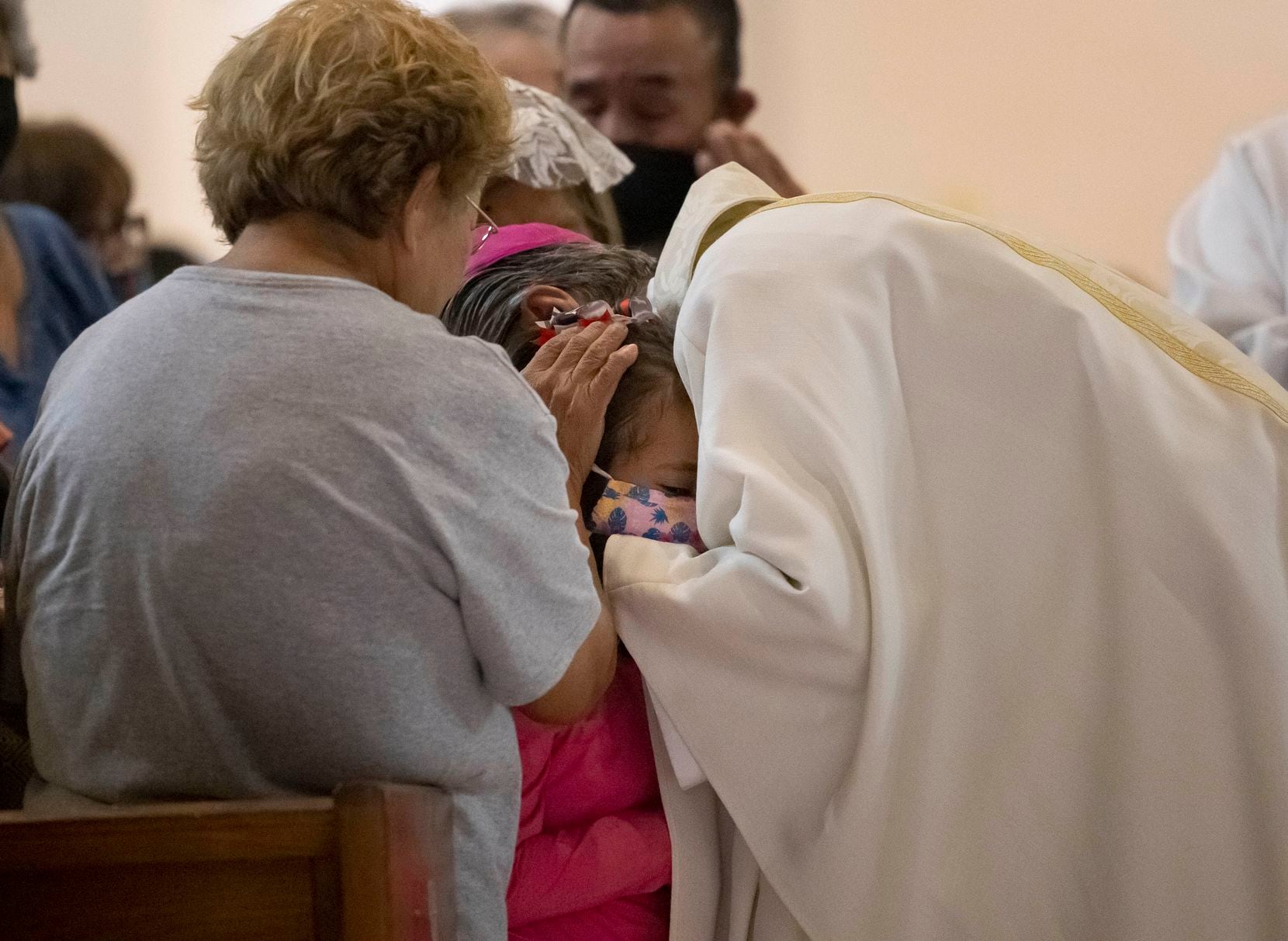 Archbishop Gustavo García-Siller prays over a child during an emergency mass held at Sacred...