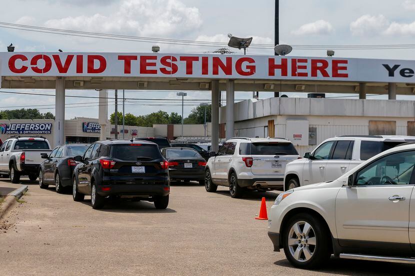 Dozens of people wait for COVID-19 testing at YesNoCovid in Dallas on Friday.