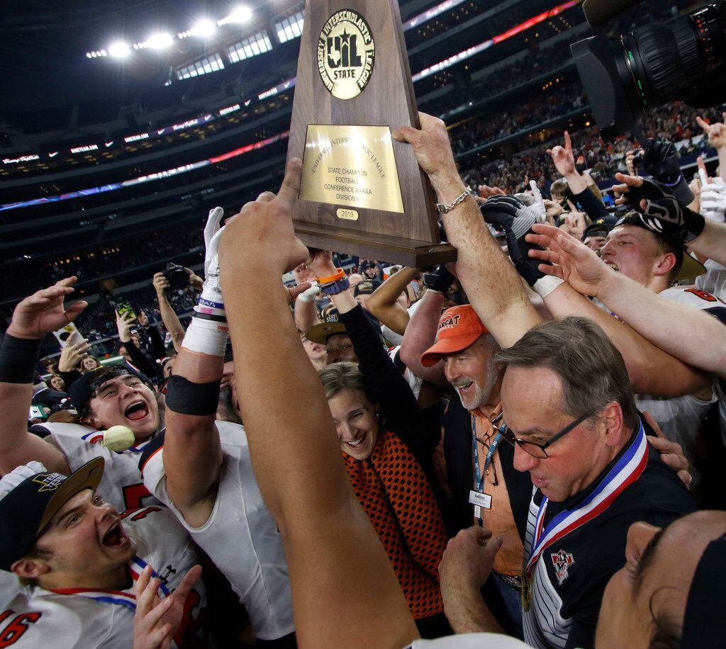 Aledo head coach Tim Buchanan, lower right, hoists the state championship as he is joined by...