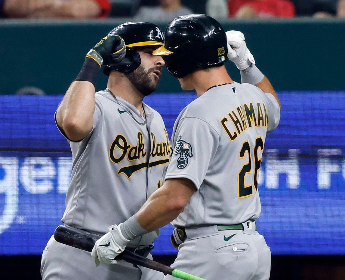 Oakland Athletics designated hitter Mitch Moreland (left) is congratulated on his seventh inning home run by teammate Matt Chapman (26) who also hit a home run during the inning at Globe Life Field in Arlington, Saturday, August 14, 2021.(Tom Fox/The Dallas Morning News)