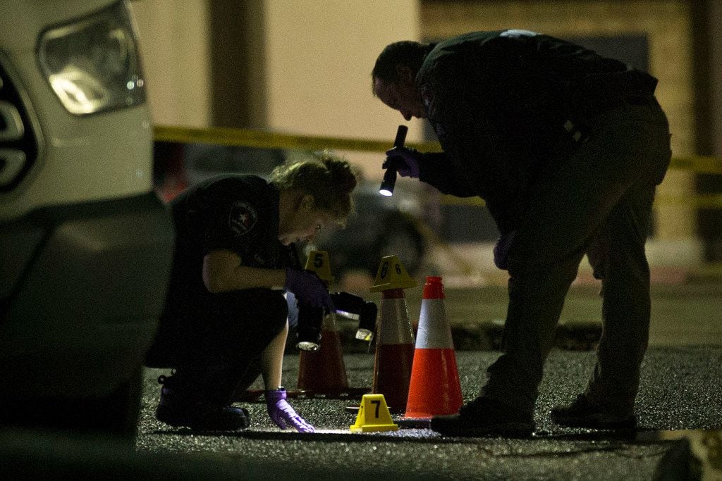 Arlington officers look for evidence at the location of an officer-involved shooting in the...