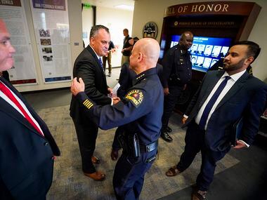 Dallas Police Chief Eddie Garcia (center) shakes hands with Special Agent in Charge Matthew J. DeSarno of FBI – Dallas after a press conference on a law enforcement action taken to address violent crime at the FBI Dallas Headquarters on Thursday, June 10, 2021, in Dallas. ATF Dallas Special Agent in Charge Jeffrey Boshek II is at left, and Acting U.S. Attorney for the Northern District of Texas Prerak Shah is at right.