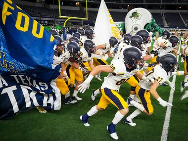 Highland Park players take the field to face Southlake Carroll in a high school football...