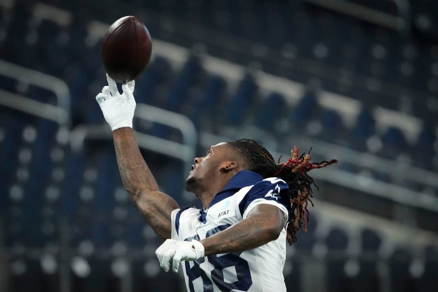 Dallas Cowboys wide receiver CeeDee Lamb reaches for a pass while warming up before an NFL...