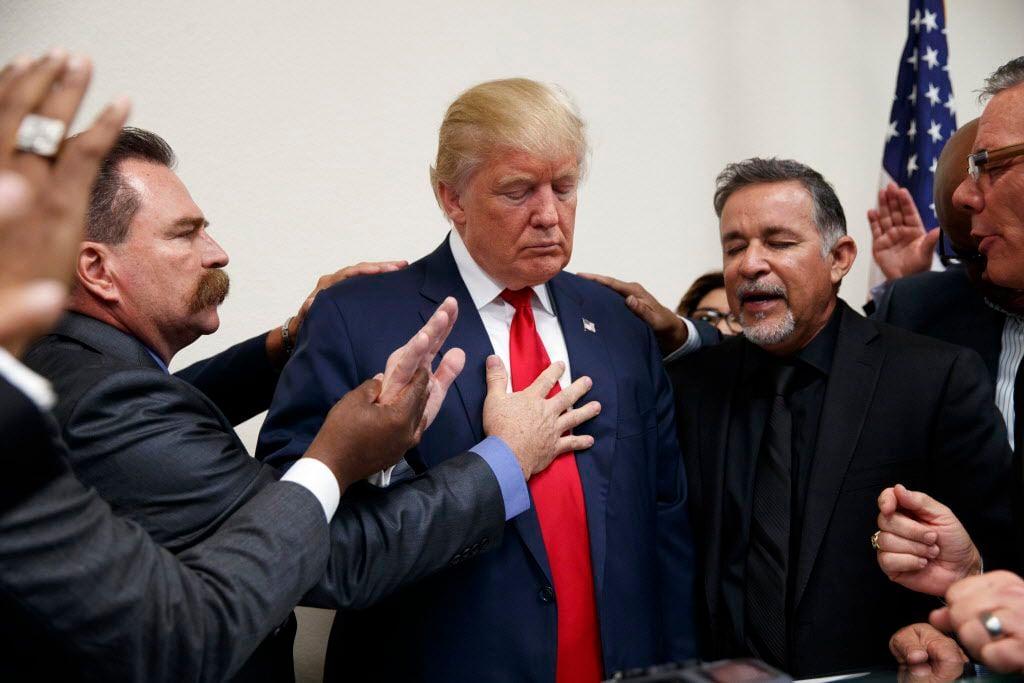 Pastors from the Las Vegas area pray with Republican presidential candidate Donald Trump...
