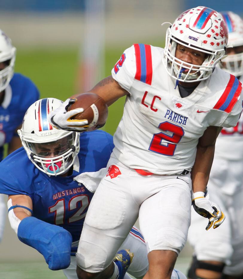 Parish Episcopal running back Andrew Paul (2) pulls from the grasp of Midland Christian...