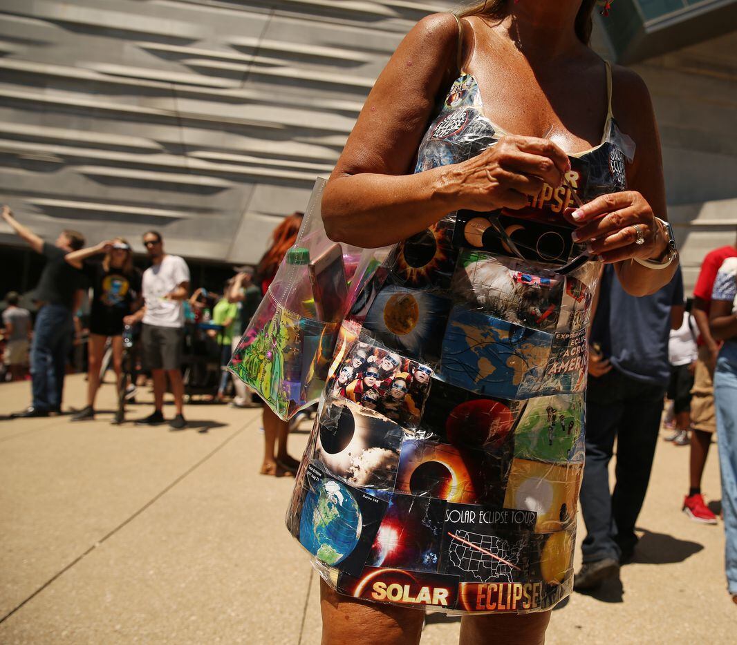 A woman wears a custom dress during a solar eclipse outdoor watch party at the Perot Museum of Nature and Science in Dallas.
