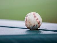 A baseball sits on top of the dugout during the eighth inning of a baseball game between the...