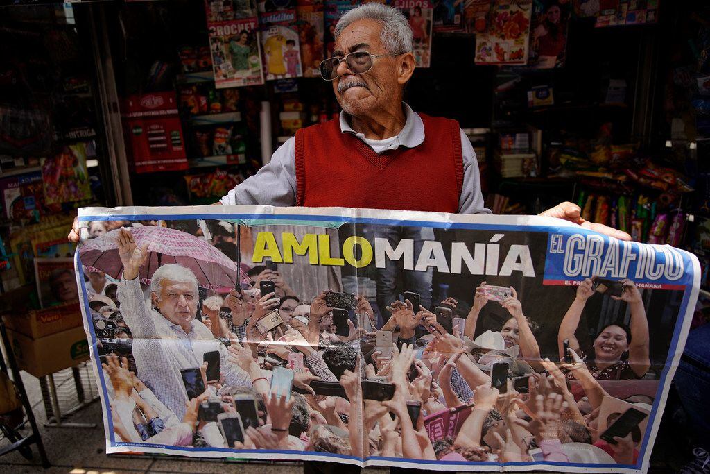Jose Luis Perez shows a poster of President-elect Andres Manuel Lopez Obrador at his...