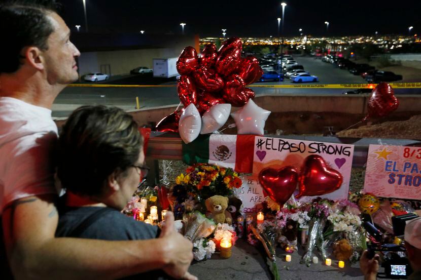 People gather at the site of a makeshift memorial for victims of the mass shooting at the...