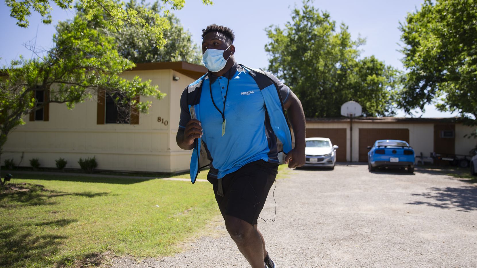 Mike Williams, a SMU defensive tackle, rushes back to his van after making deliveries while...