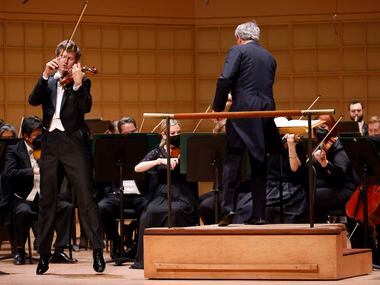 Скрипач Джеймс Эннис (в прыжке слева) исполняет скрипичный концерт Элгара с Далласским симфоническим оркестром под управлением Фабио Луизи в Симфоническом центре Мерсона в Далласе, 13 января 2022 года.