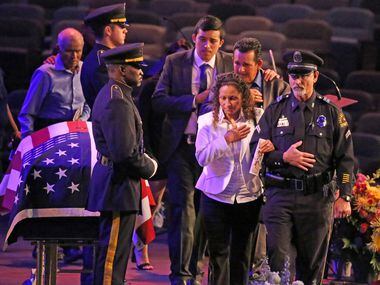 The family of slain Dallas Officer Rogelio Santander walks past his flag-draped casket...