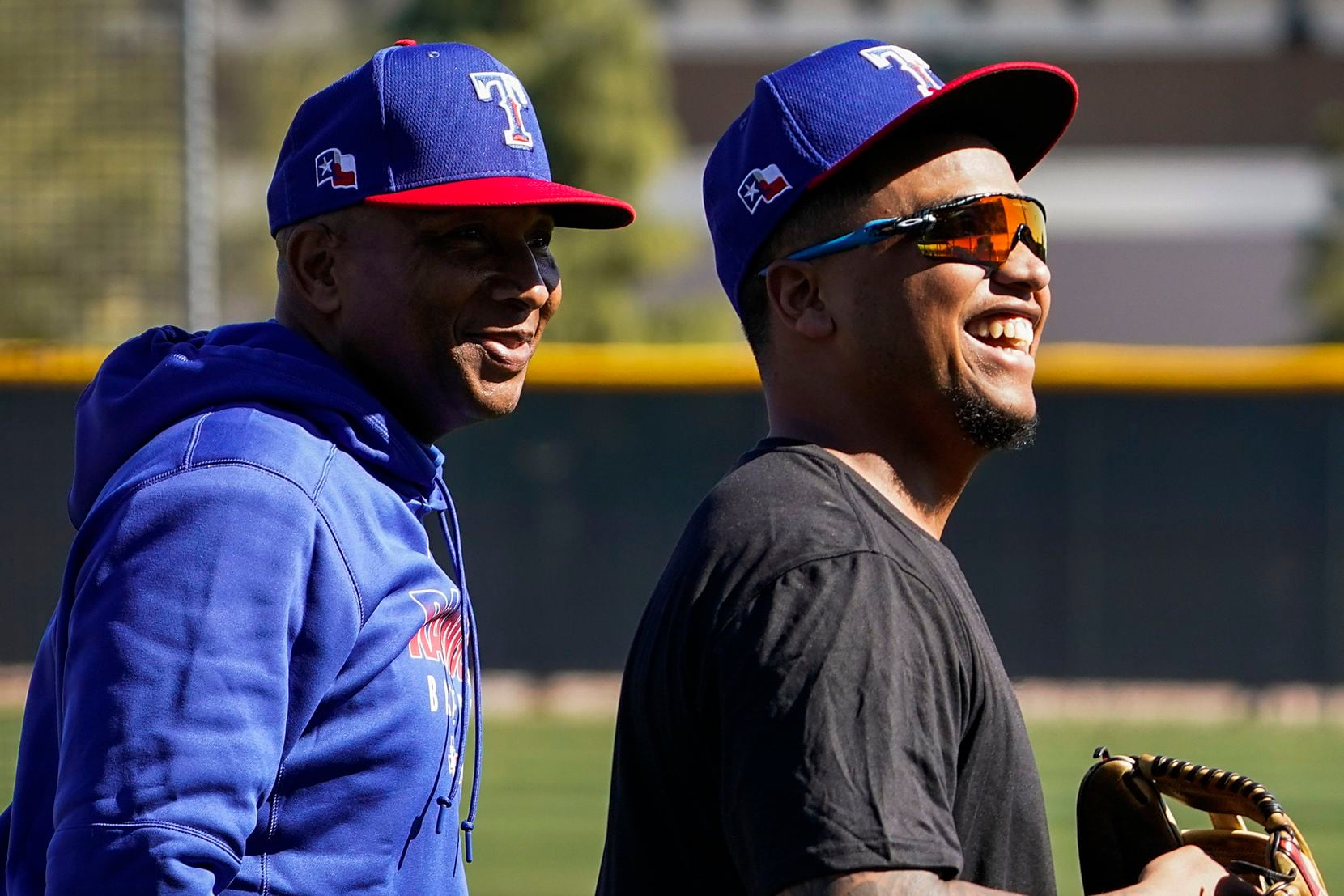 Texas Rangers outfielder Willie Calhoun (right) laughs with third base coach Tony Beasley during the first spring training workout for pitchers and catchers at the team's training facility on Wednesday, Feb. 12, 2020, in Surprise, Ariz. 