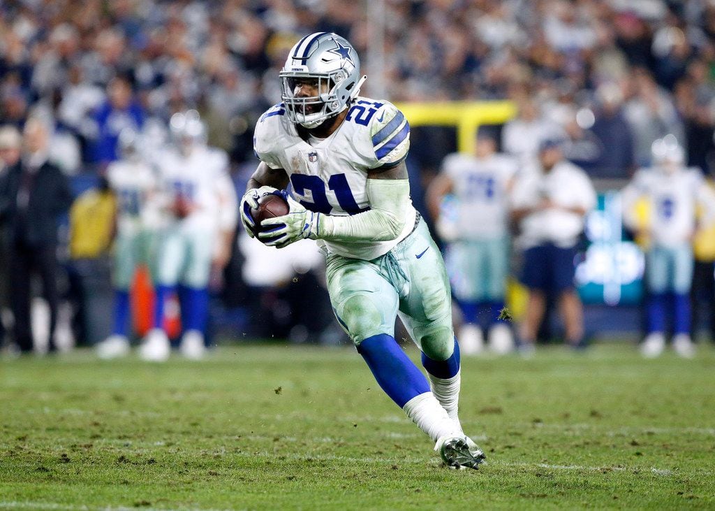 Dallas Cowboys running back Ezekiel Elliott (21) carries the ball after quarterback Dak...