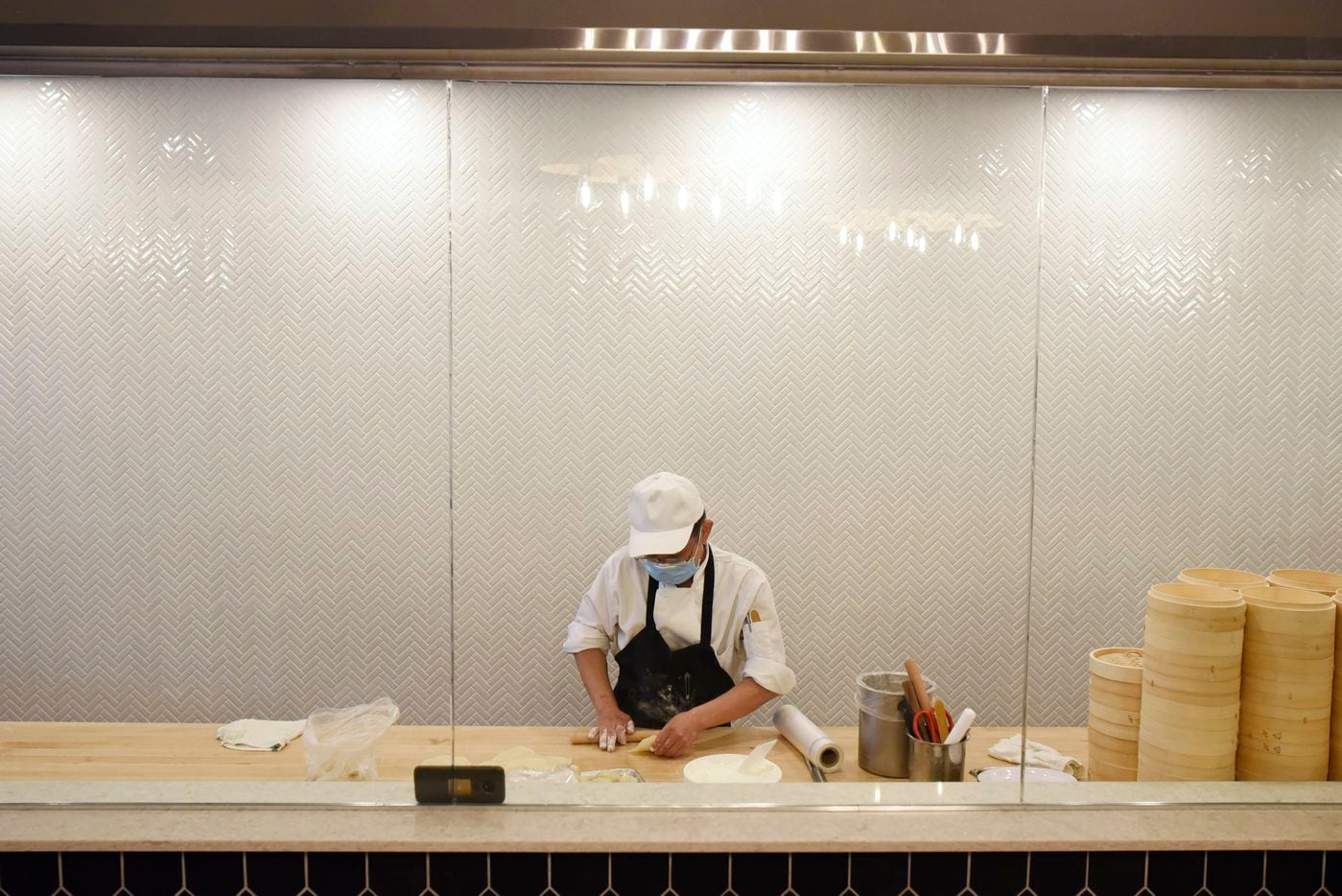 Dumpling chef Harrison Huang makes radish dumplings behind a window at Kitchen Master...