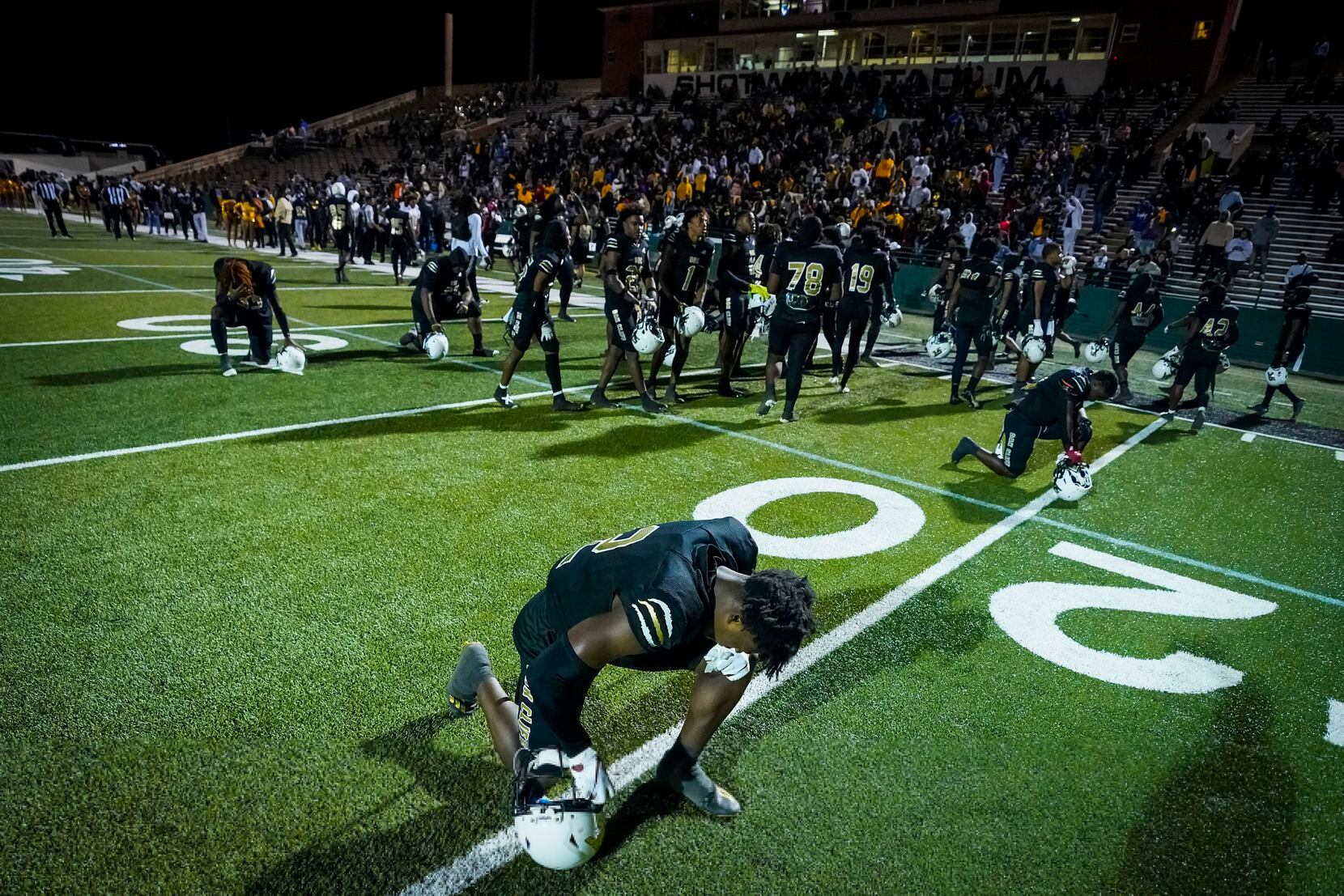 South Oak Cliff defensive back Kyron Chambers (2) kneels in prayer before the first half of...