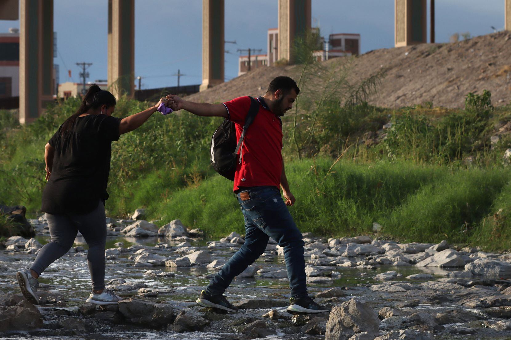 A woman and a man from Venezuela cross the Rio Grande from Ciudad Juárez, Mexico into El...