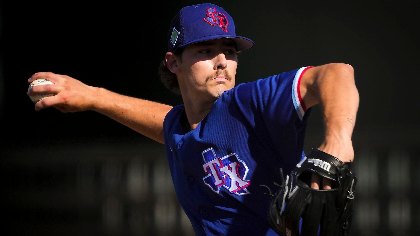 Texas Rangers pitcher Cole Winn delivers during the sixth inning of a spring training game...