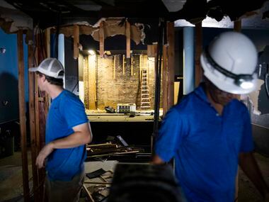 Rex Johnson (left) and Omar Flores work to remove the old sound booth in the The Texas...