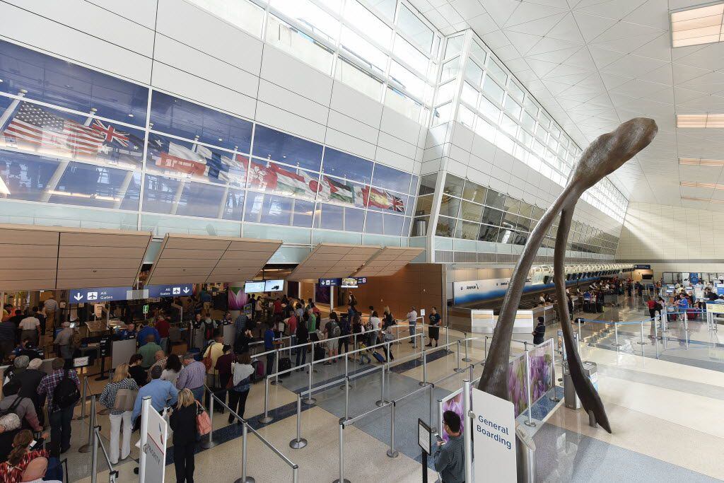 Passengers pass through security at Terminal D at Dallas/Fort Worth International Airport....