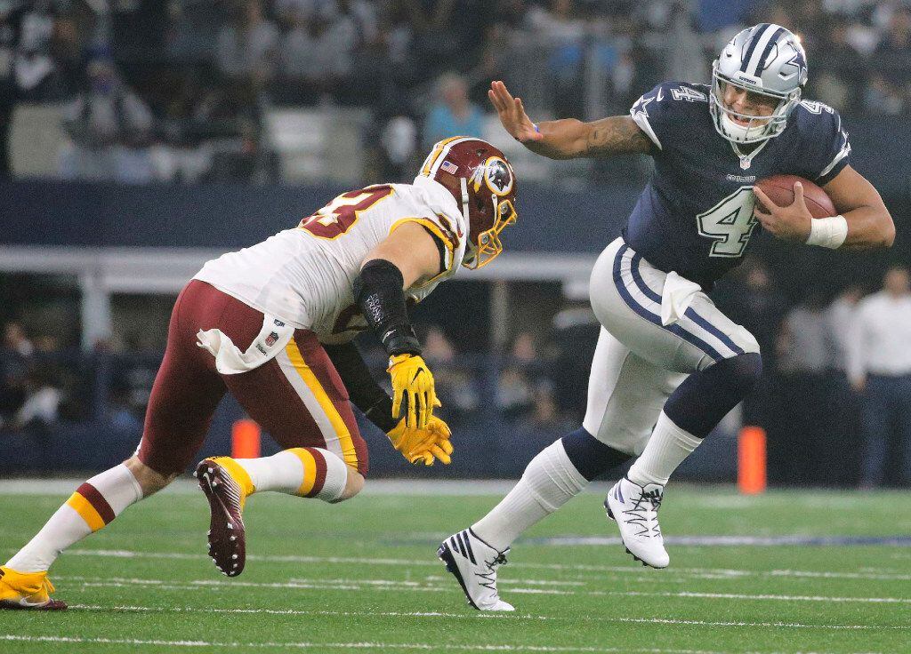Dallas Cowboys quarterback Dak Prescott (4) applies the stiff-arm to Washington Redskins...