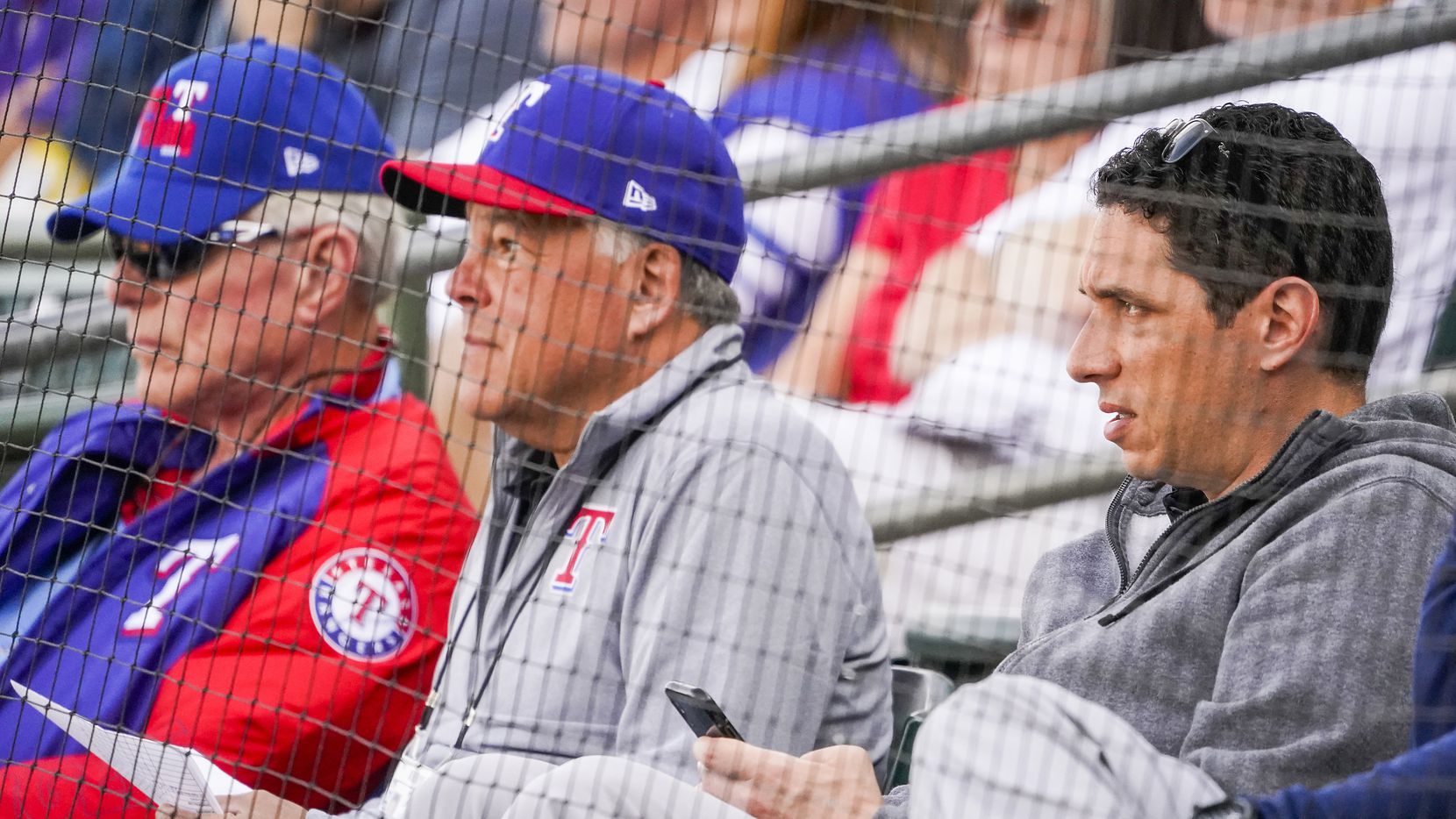 Texas Rangers general manager Jon Daniels (right) watches with co-chairman and managing partner Ray C. Davis (left) and chairman, ownership committee and chief operating office Neil Leibman (center) during the third inning of a spring training game against the Chicago Cubs at Surprise Stadium on Thursday, Feb. 27, 2020, in Surprise, Ariz.