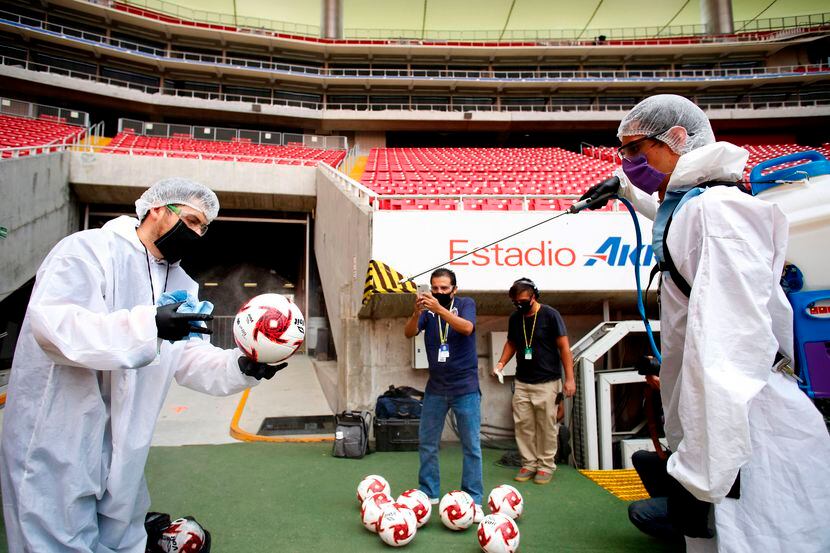 Trabajadores de Chivas de Guadalajara desinfectan los balones con los que se disputó un...