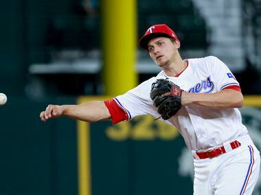 Texas Rangers shortstop Corey Seager (5) throws to first for an out during the second inning...